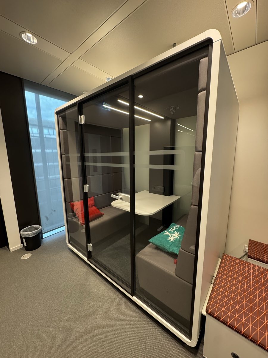 A small glass meeting pod with two benches and a table: the Skill++ headquarters